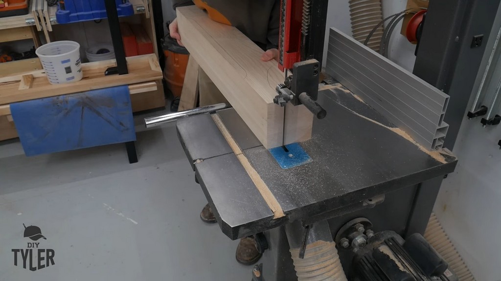 man running hard maple wood piece through bandsaw