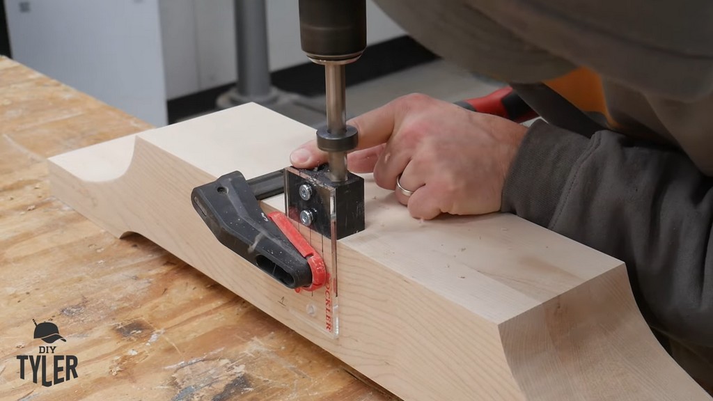 man drilling dowel hole into pedestal base piece