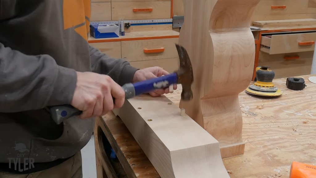 man hammering dowels into place