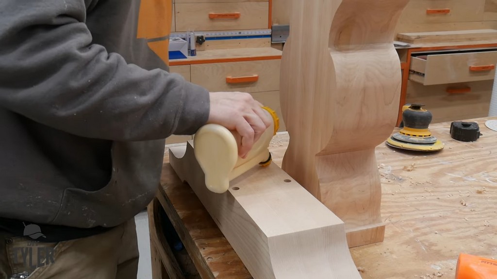 man applying wood glue to dowels for pedestal pieces