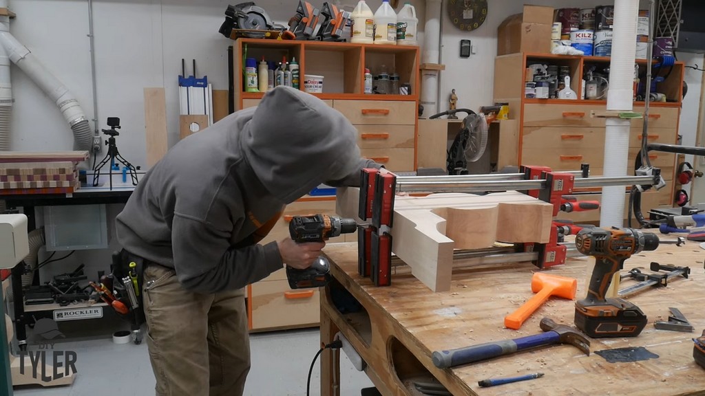 man drilling hole into pedestal pieces