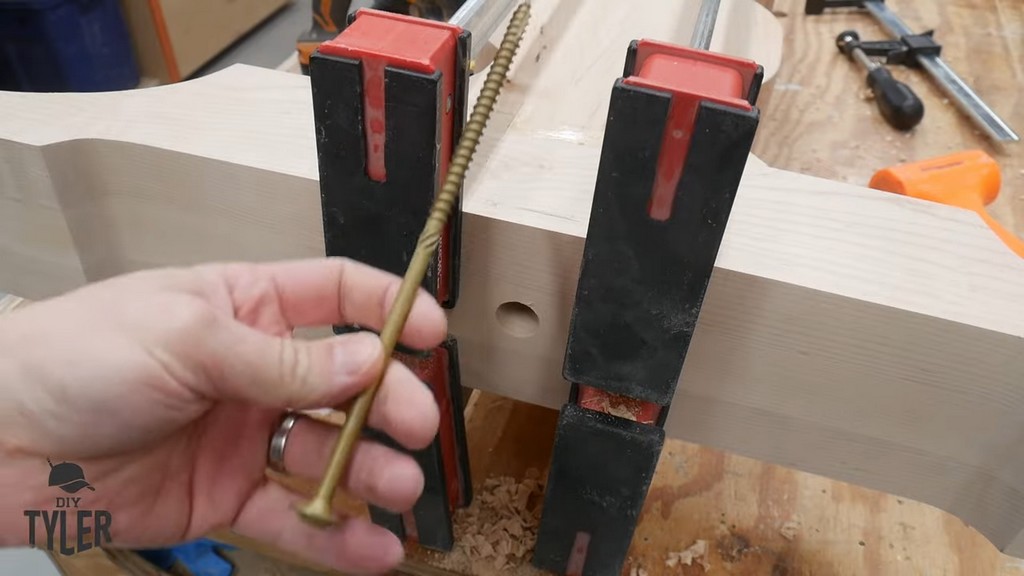 man holding up eight-inch structural screw