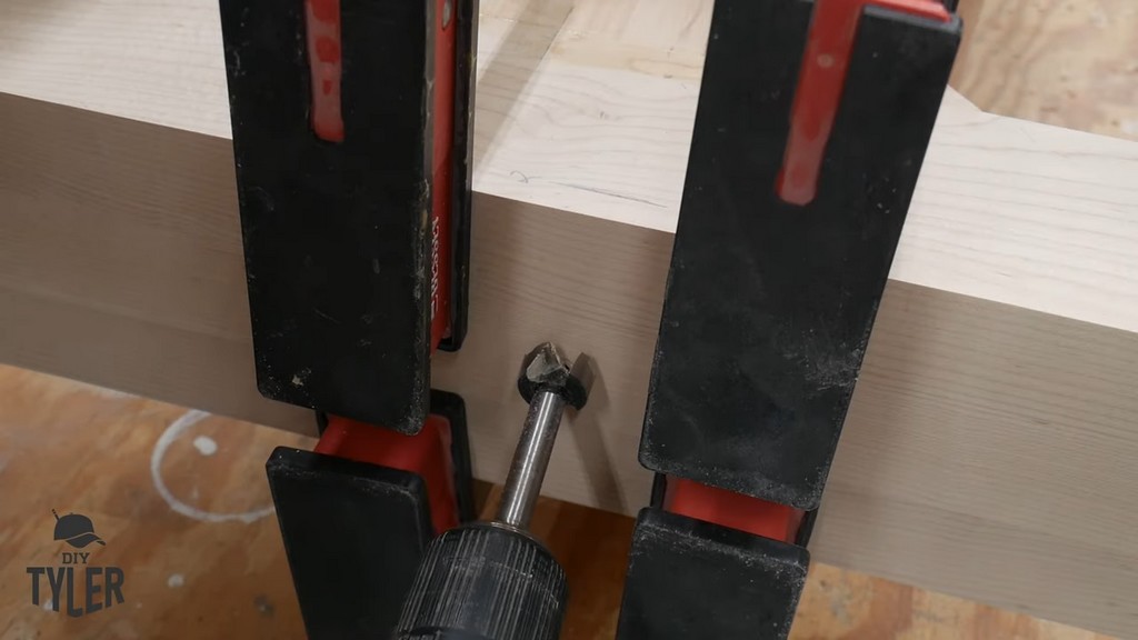 man drilling hole into pedestal pieces