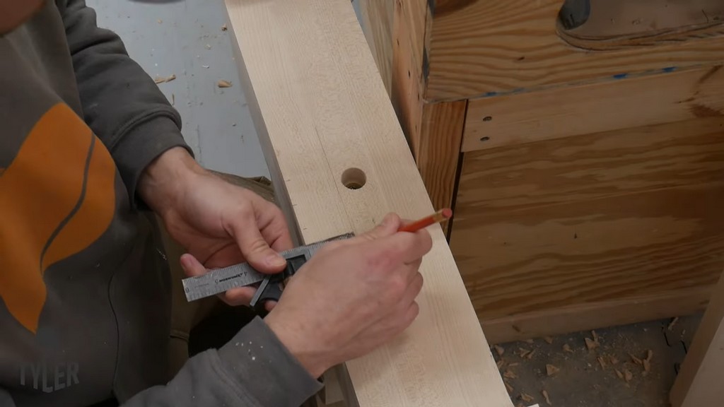 man marking spaces for holes in pedestal piece