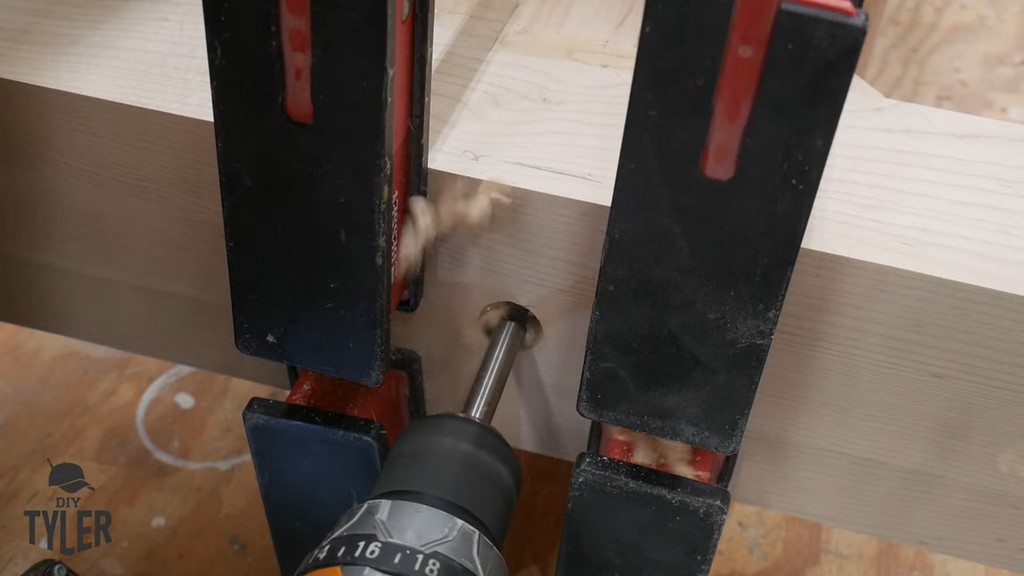 man drilling hole into pedestal pieces