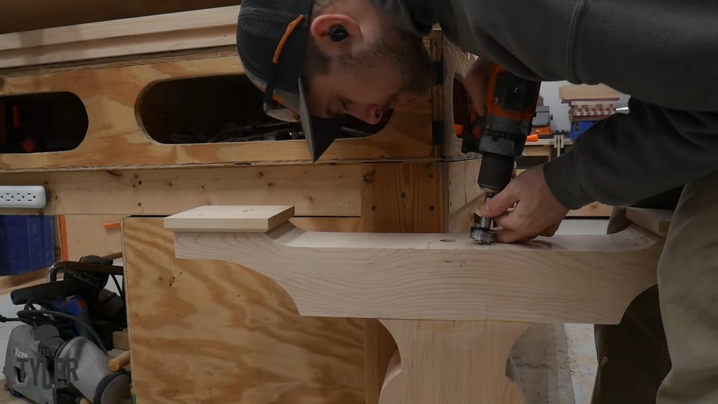 man drilling hole into pedestal piece