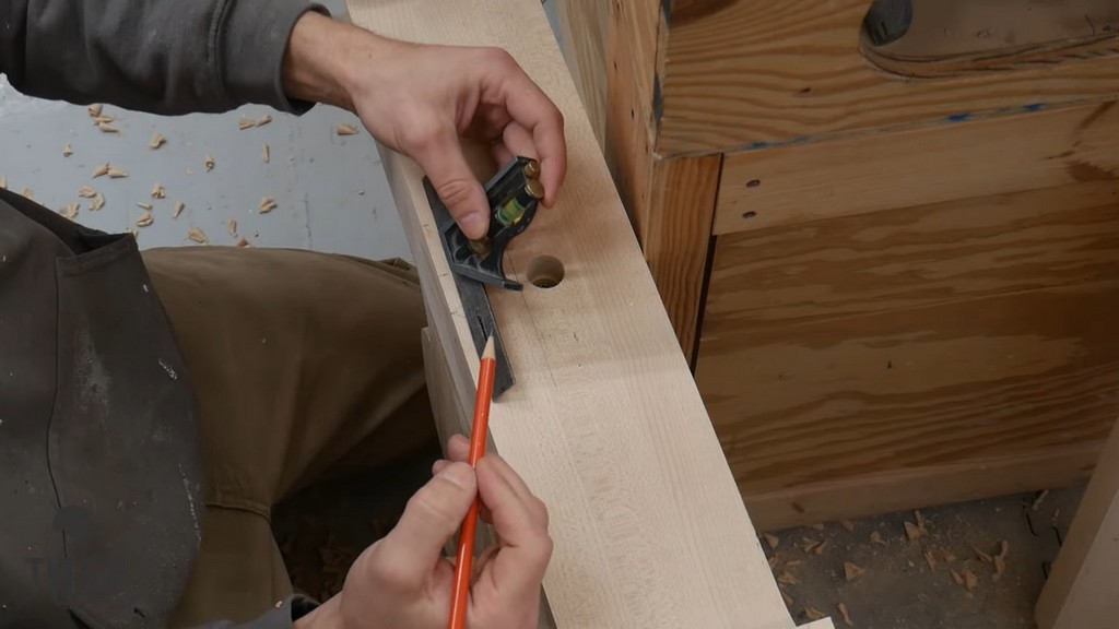 man marking spaces for holes in pedestal piece