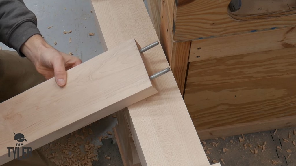 man demonstrating cross-brace piece for DIY D&D game table