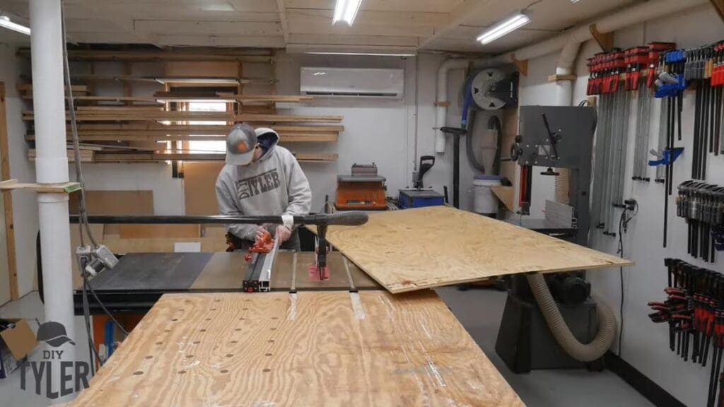 man cutting plywood at table saw