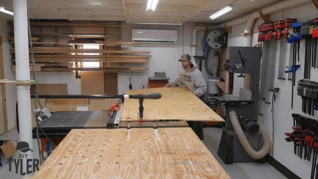 man cutting plywood at table saw