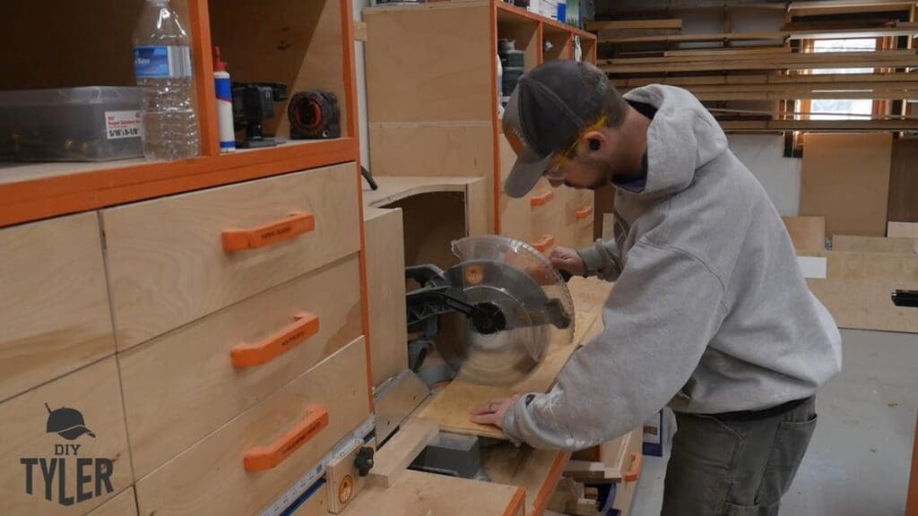 man cutting plywood at miter saw