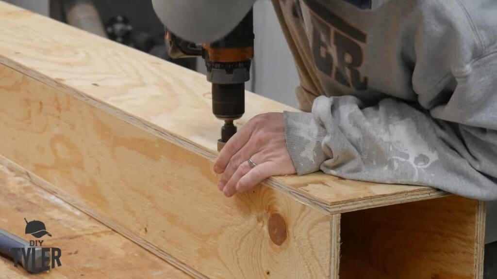man fastening plywood pieces together for steam box