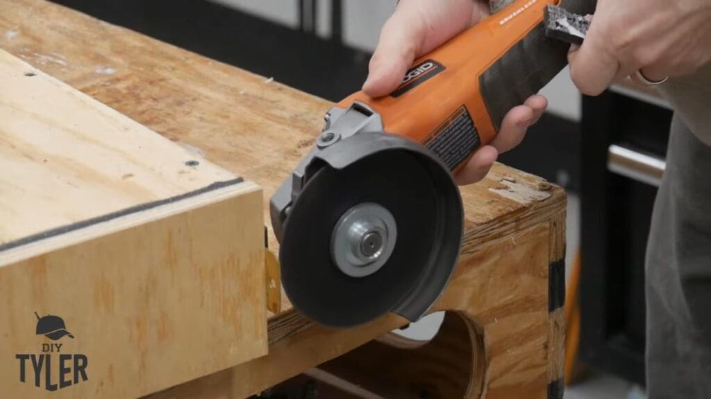 man cutting off part of hinge with angle grinder