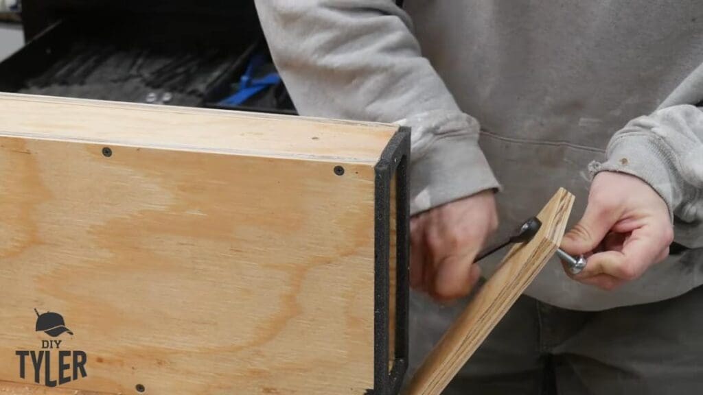 man tightening bolt for door to steam box