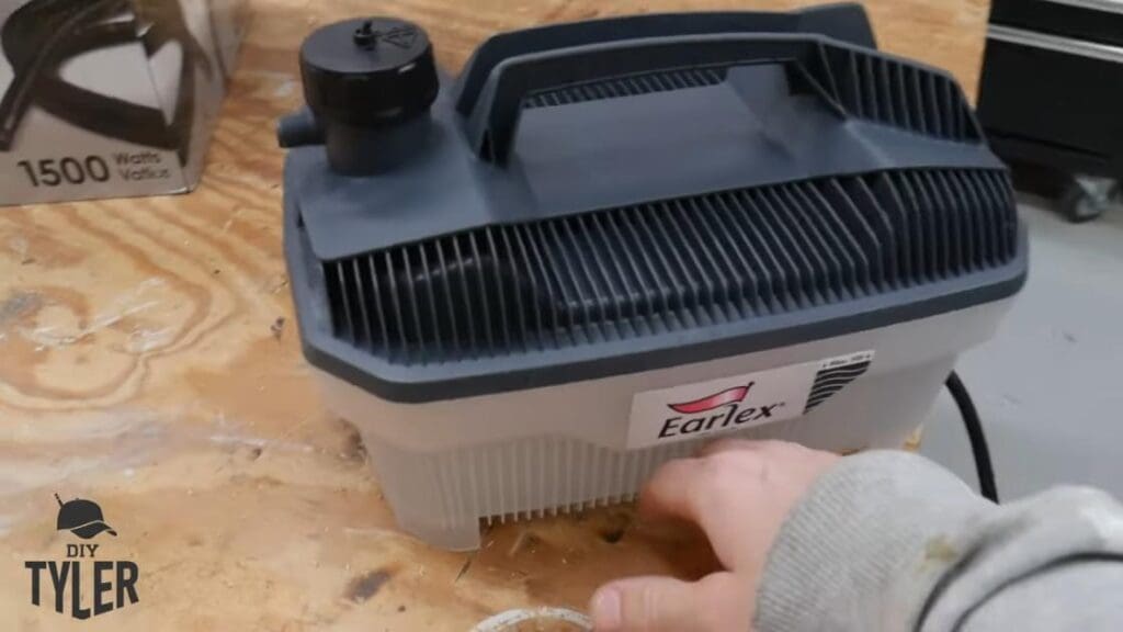 man gesturing to Earlex steam generator on workshop table