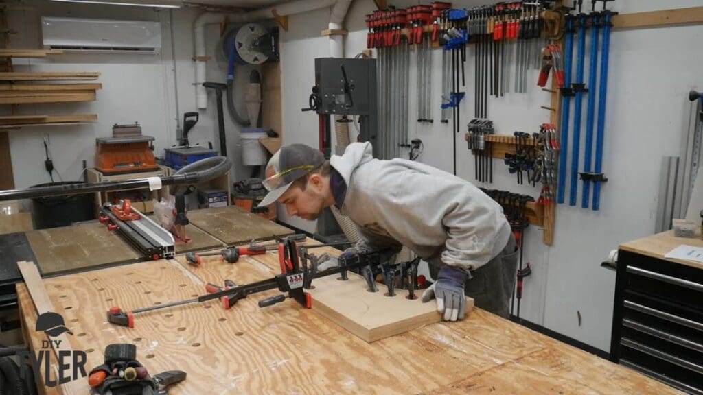 man bending steam-treated wood onto mold