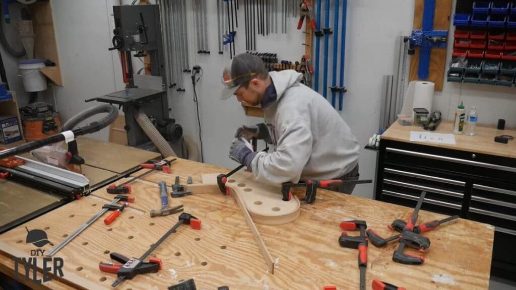 man bending steam-treated wood onto mold