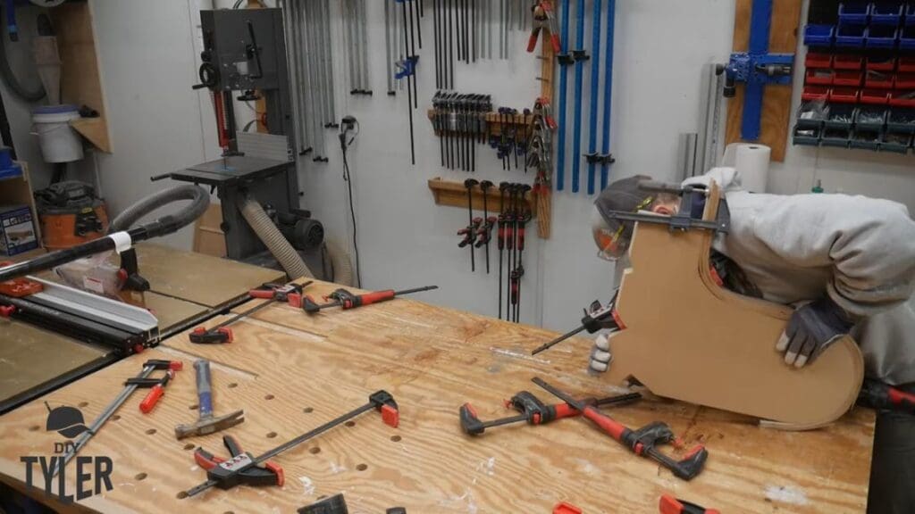 man bending steam-treated wood onto mold