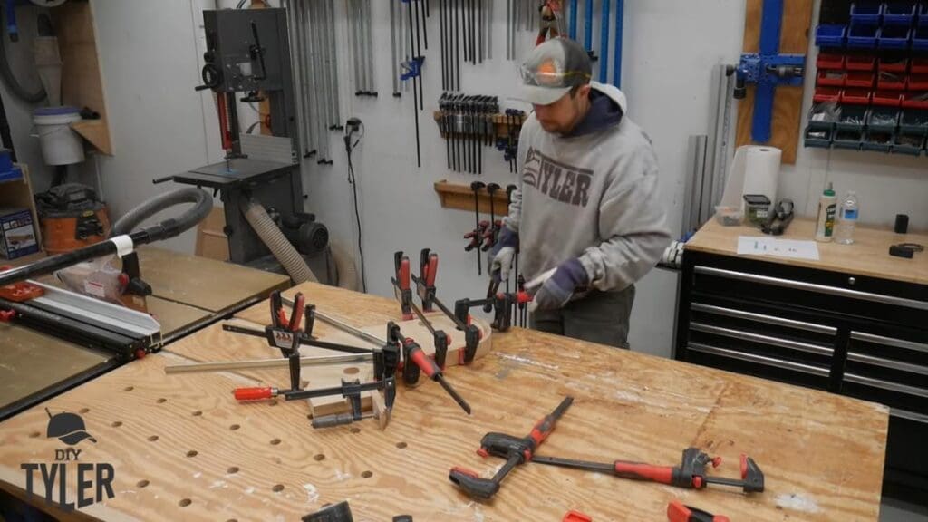 man adjusting clamps for bent stream-treated wood