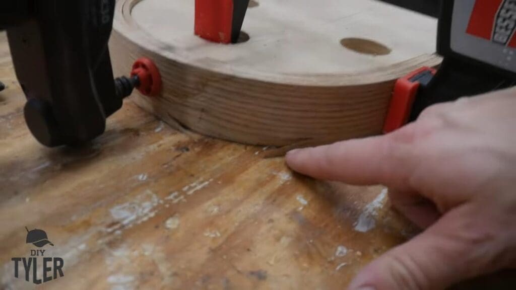 man indicating break in bent steam-treated wood
